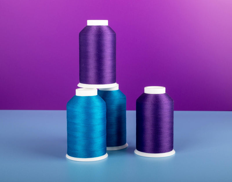 blue and purple cone of soft touch thread against a purple background