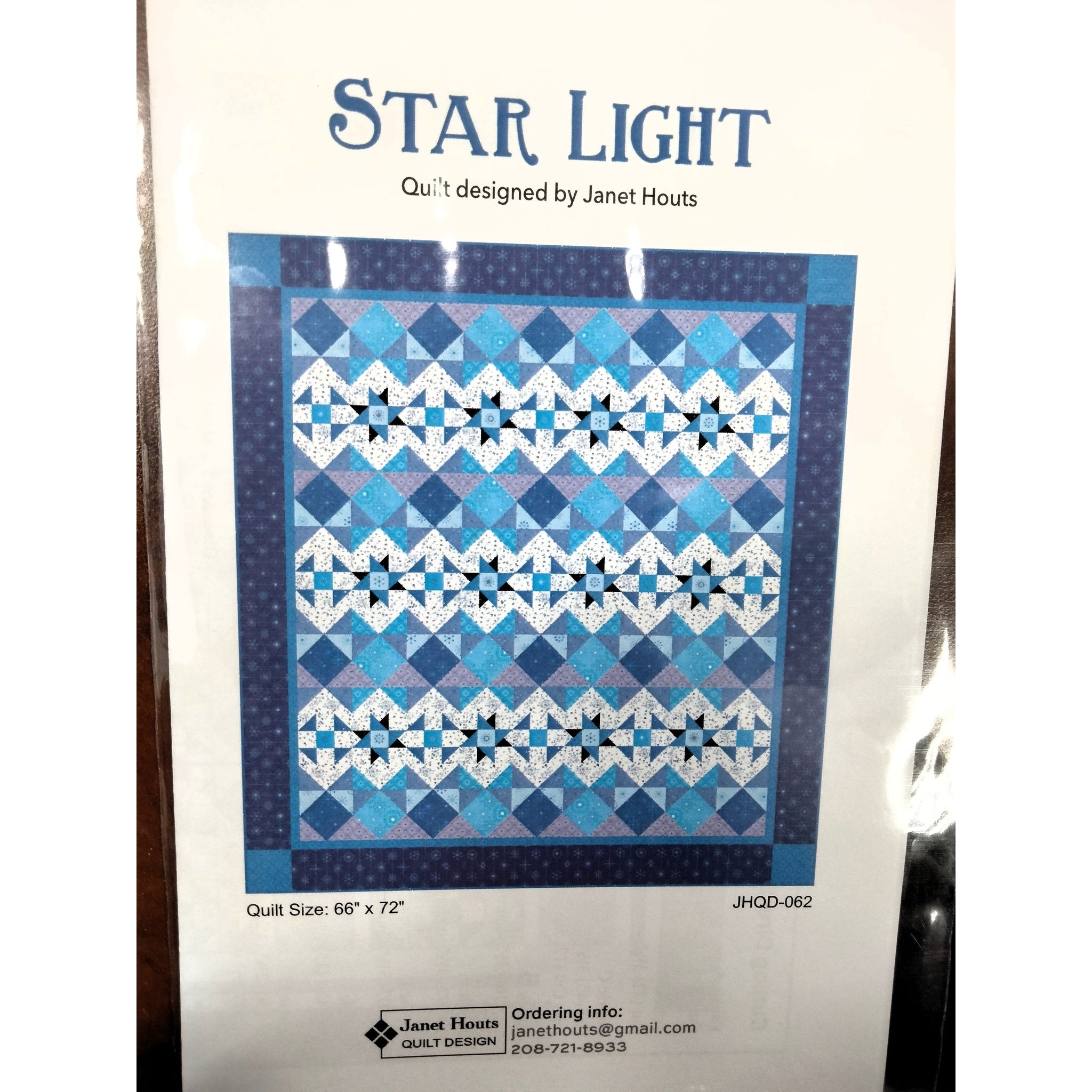 A quilt pattern featuring alternating rows of blue star blocks and diamond shapes in shades of blue, white, and navy with a dark blue border.
