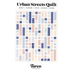 A modern quilt pattern featuring rectangular blocks in soft blues, corals, and creams with small floral accent pieces arranged in a contemporary layout.