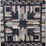 Patchwork quilt featuring a large star pattern in navy, cream, and brown fabrics with woodland animal motifs and decorative borders.