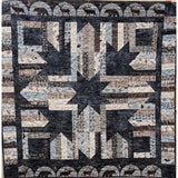 Patchwork quilt featuring a large star pattern in navy, cream, and brown fabrics with woodland animal motifs and decorative borders.
