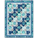Blue and teal star and diamond pattern quilt with floral fabrics, featuring geometric blocks on gray background with decorative border